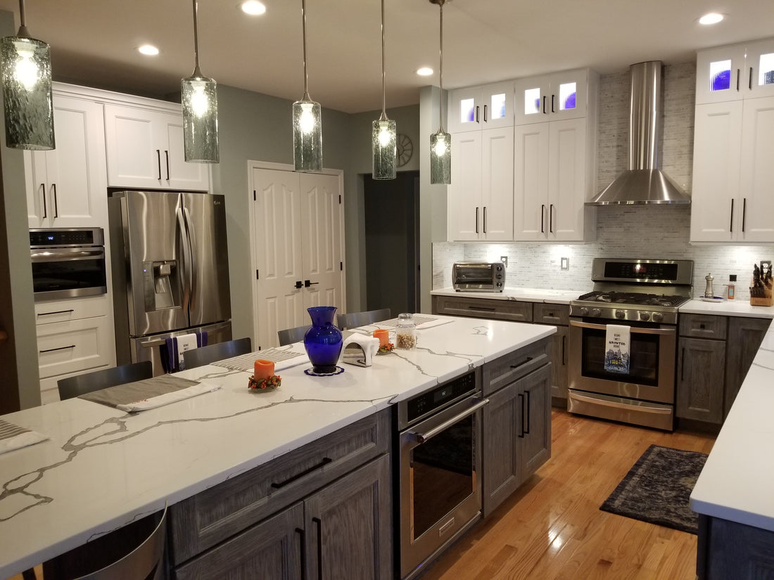 Bicycle Glass Co. single pendant lights in brushed nickel with lunar 515s in gray and downrods over a marble kitchen island