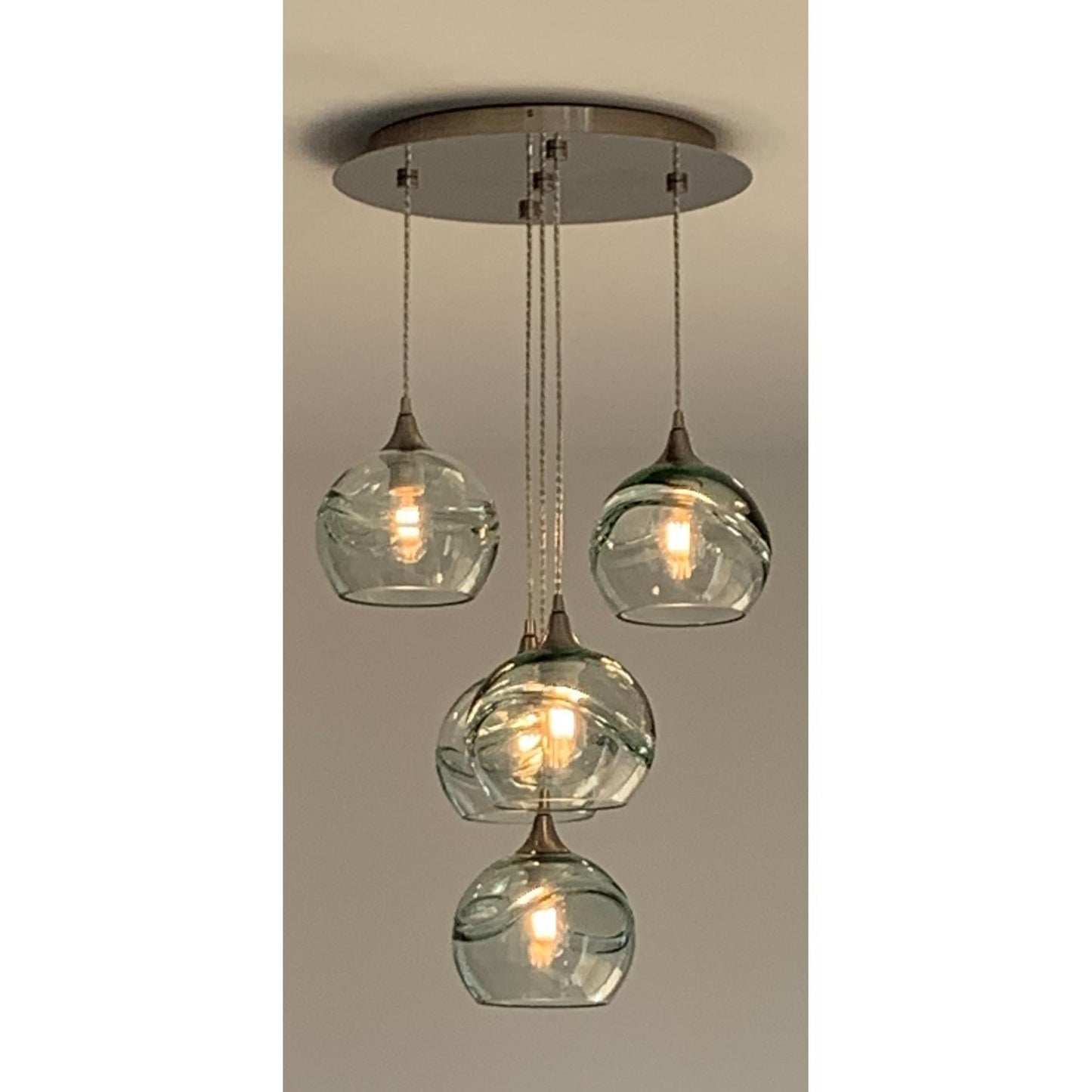 Bicycle Glass Co 767 Swell: 5 Pendant Cascade Chandelier, Eco Clear Glass, Brushed Nickel Hardware, Lifestyle Photo, Living Room, Close Up Shot, Light Bulbs On