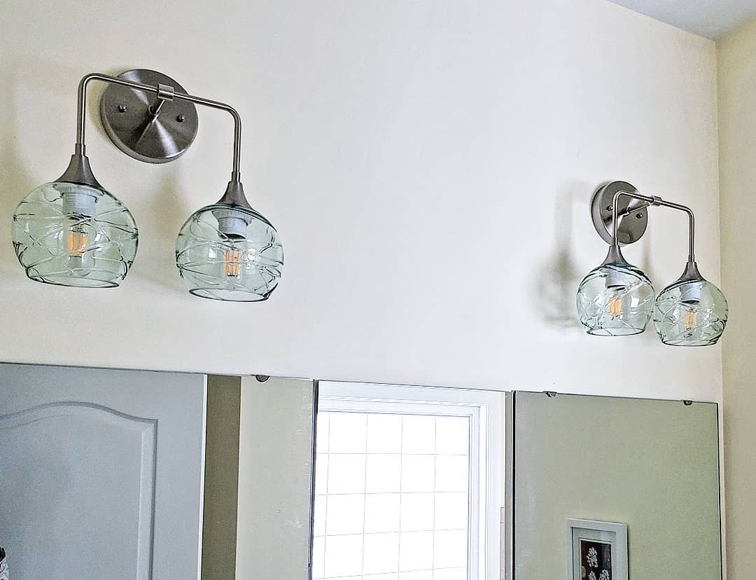 Bicycle Glas Co Double Sconces in brushed nickel with spun 763s in clear over a bathroom mirror vanity