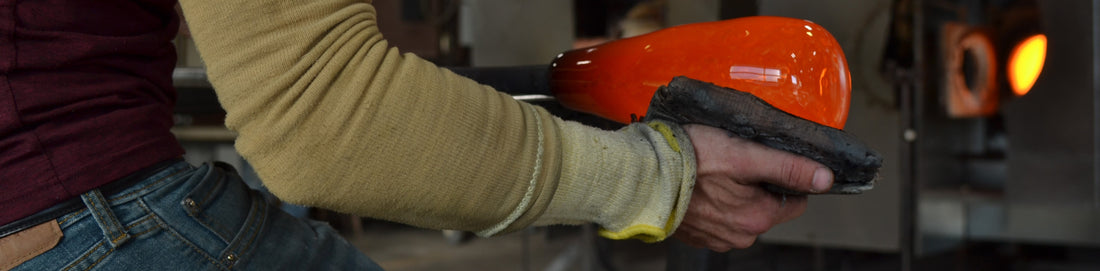 Photo of glassblower papering a starter bubble