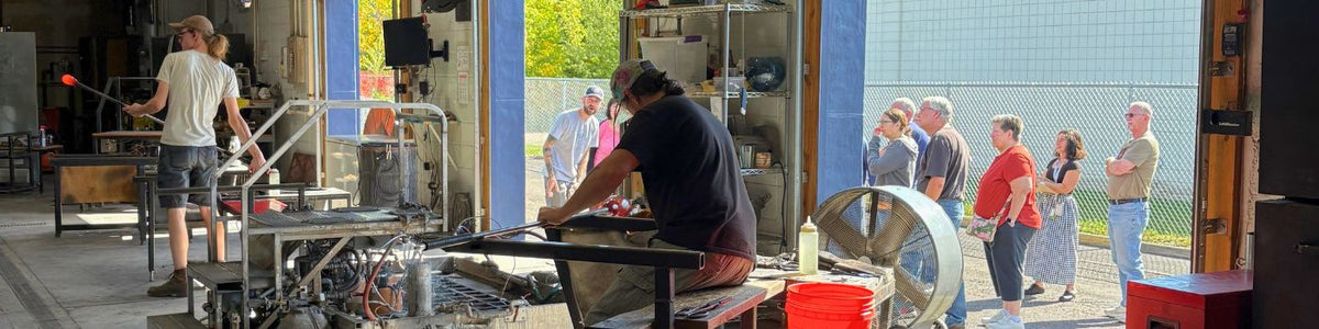 glassblowers working in our hotshop with community members watching from outside our garage doors